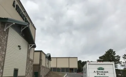 Storage Place moving truck in front of storage facility building.