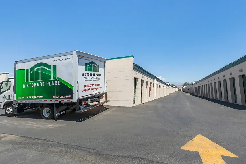 Storage units with paved parking and moving truck.