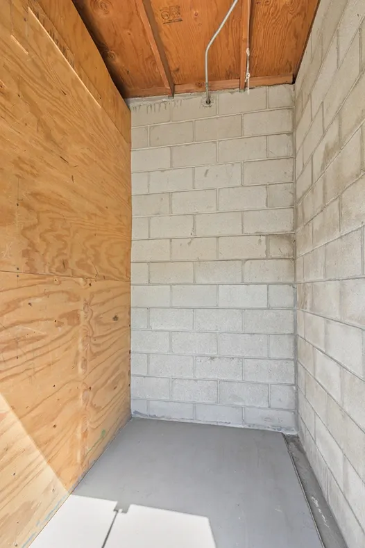 Close up of a back corner of a wood and concrete storage unit.