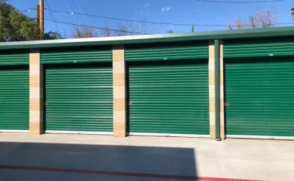 Green outdoor storage units in a row.